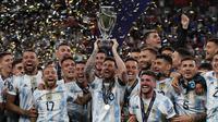 Pada tahun berikutnya, Lionel Messi berhasil memenangi trofi Finalissima 2022 bersama Argentina dengan mengalahkan Juara Euro 2020, Italia. Pertandingan yang berlangsung di Stadion Wembley itu berakhir dengan skor 3-0 untuk kemenangan La Albiceleste. Gol kemenangan Argentina kala itu dicetak oleh Lautaro Martinez, Angel Di Maria, dan Paulo Dybala. (AFP/Adrian Dennis)