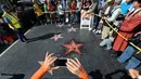 Warga melihat perbaikan Hollywood Walk of Fame milik Donald Trump usai dirusak seorang pria bernama James Lambert Otis , California, AS (26/10). Nama Donald Trump sendiri masuk kedalam daftar Walk of Fame pada tahun 2007. (David McNew/Getty Images/AFP)