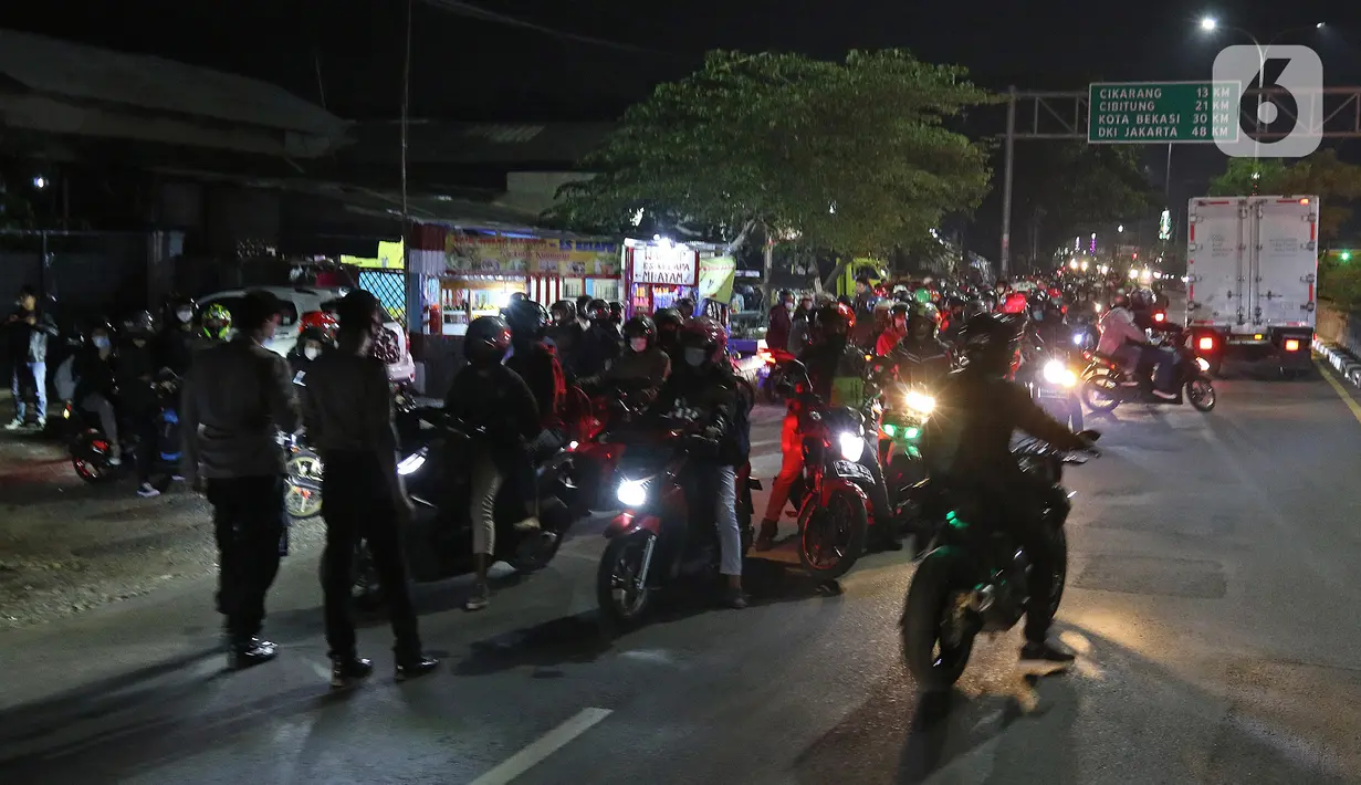 Petugas Kepolisian melakukan penyekatan pemudik motor di Kedungwaringin, Kabupaten Bekasi, Jawa Barat, Minggu (9/5/2021). H-3 jelang Hari Raya Idul Fitri 1422H petugas gabungan memperketat penjagaan pemudik di perbatasan Kabupaten Bekasi dan Karawang. (Liputan6.com/Herman Zakharia)