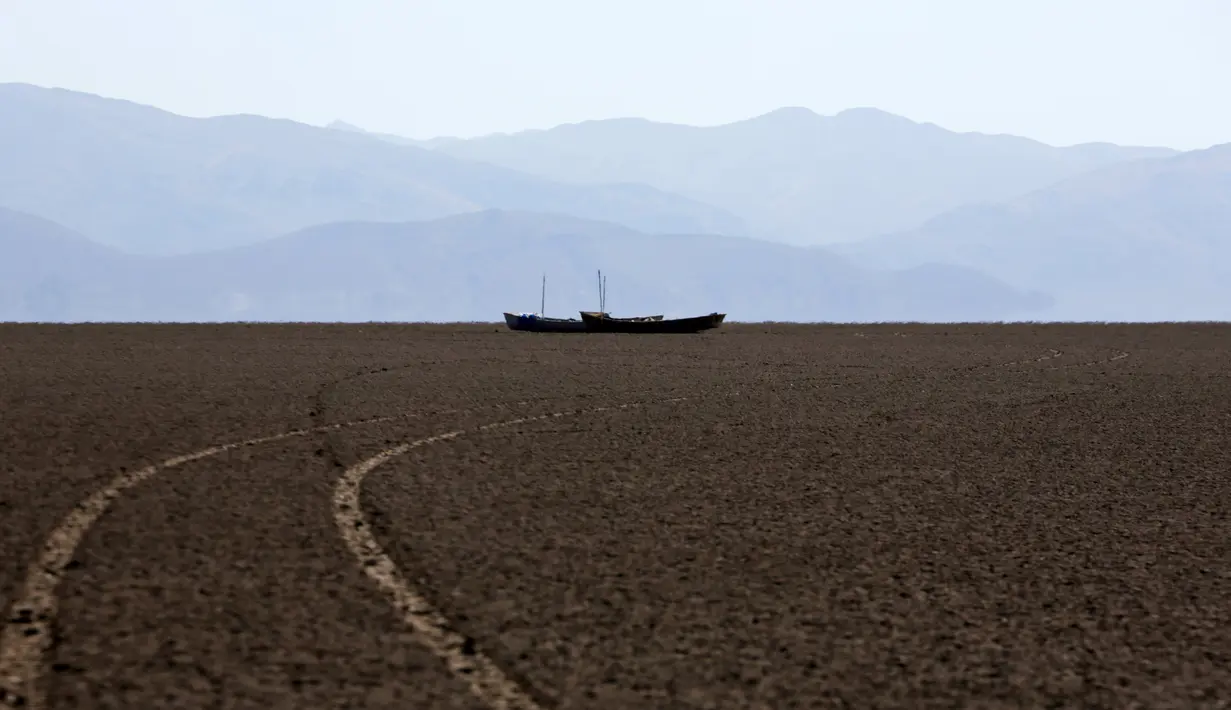 Perahu nelayan yang ditinggalkan begitu saja di tengah Danau Poopo, La Paz, Bolivia, (17/12). Sejumlah warga terpaksa bermigrasi dari wilayah tersebut. (REUTERS/David Mercado)