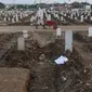 Aktivitas petugas pemakaman di TPU Khusus COVID-19 Rorotan, Jakarta, Rabu (11/8/2021). Pemerintah menghapus data angka kematian dari indikator penanganan COVID-19. Pemerintah beralasan terjadi permasalahan dalam input data angka kematian COVID-19, (Liputan6.com/Helmi Fithriansyah)