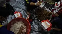 Petugas Taruna Siaga Bencana (Tagana) menyiapkan nasi kotak di Dapur Umum Kementerian Sosial Peduli Dampak Covid-19 di Kompleks Gedung Konvensi TMP Nasional-Utama, Kalibata, Jakarta, Rabu (8/4/2020). Dalam sehari, petugas menyiapkan 5.000 hingga 9.000 paket nasi bungkus. (Liputan6.com/Faizal Fanani)
