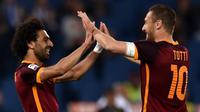 Mohamed Salah (kiri) dan Francesco Totti (kanan) merayakan gol ke gawang Bologna pada laga Serie A di Olimpico, Roma, Senin (11/4/2016). (AFP/Alberto Pizzoli)
