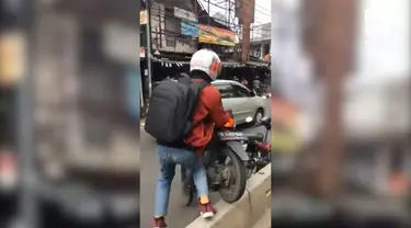 Para pengguna menerapkan gotong royong dalam mengangkat motor.