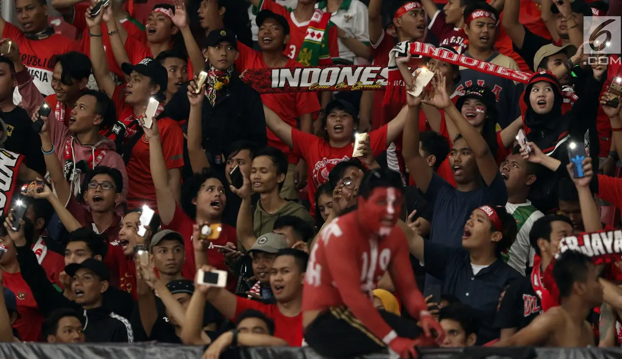 Suporter tim Garuda membentangkan syal saat menyaksikan laga Timnas Indonesia melawan Timor Leste pada penyisihan grup B Piala AFF 2018 di Stadion GBK, Jakarta, Selasa (13/11). Indonesia unggul 3-1. (Liputan6.com/Helmi Fithriansyah)