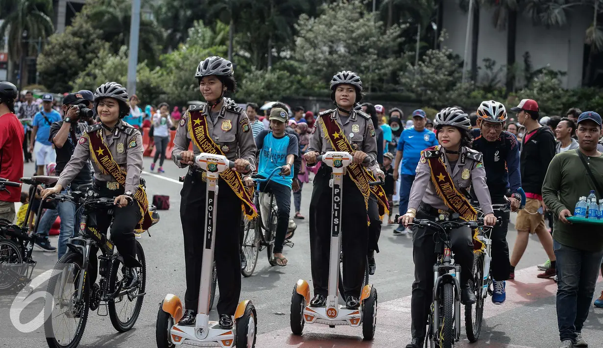 Sejumlah polwan bersepeda melakukan patroli diantara warga yang sedang beraktifitas di kawasan Bunderan HI, Jakarta (15/1). Patroli bersepeda tersebut untuk memberikan rasa nyaman kepada warga yang beraktivitas dalam HBKB. (Liputan6.com/Faizal Fanani)