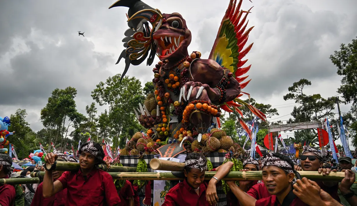 Warga mengarak kendaraan hias berisi durian dan buah lainnya selama festival durian “Kenduren Wonosalam” di desa Wonosalam, Jombang, Jawa Timur, 23 Februari 2025. (JUNI KRISWANTO/AFP)