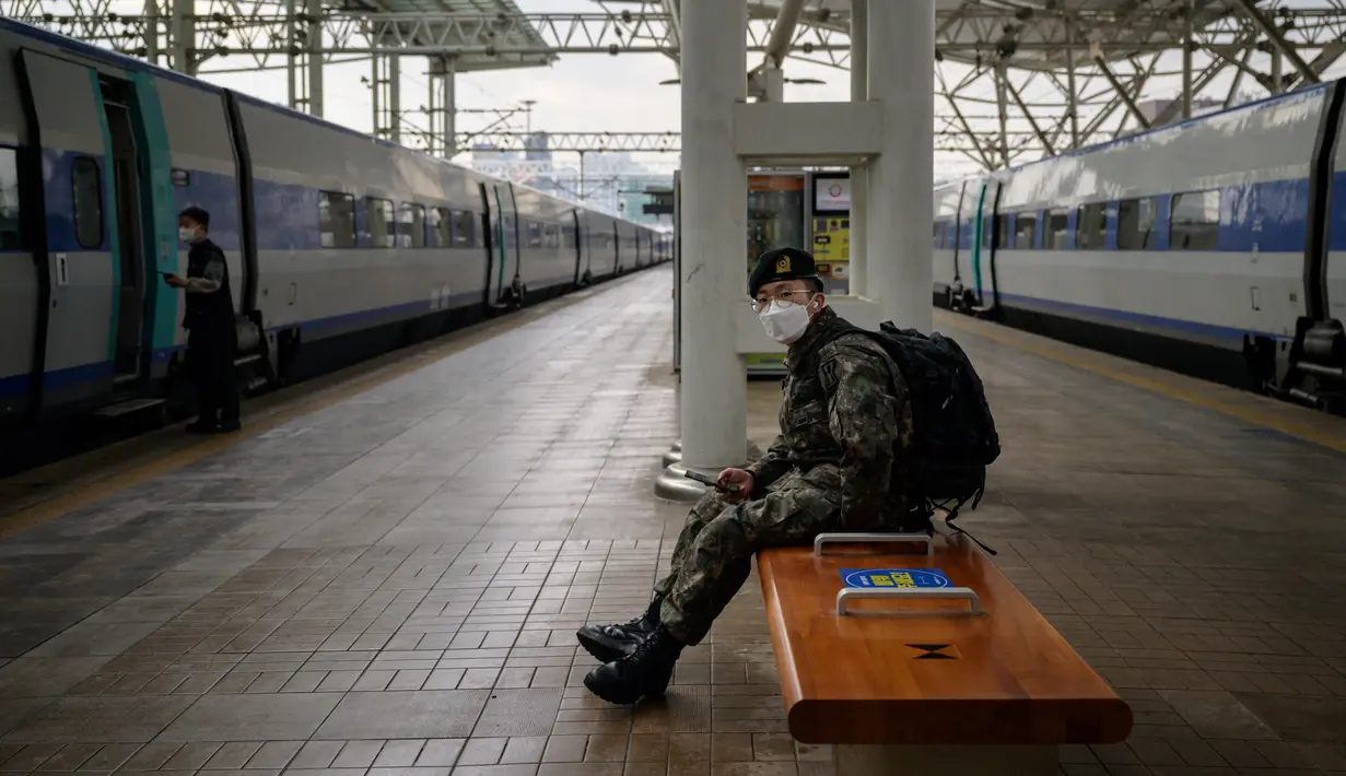 Seorang tentara menunggu untuk naik kereta menjelang liburan Tahun Baru Imlek di stasiun Seoul, Korea Selatan, Rabu (10/2/2021). Liburan Tahun Baru Imlek dimulai pada 11 Februari, dan puluhan juta orang Korea biasanya melakukan perjalanan ke seluruh negeri untuk pertemuan keluarga. (Ed JONES/AFP)