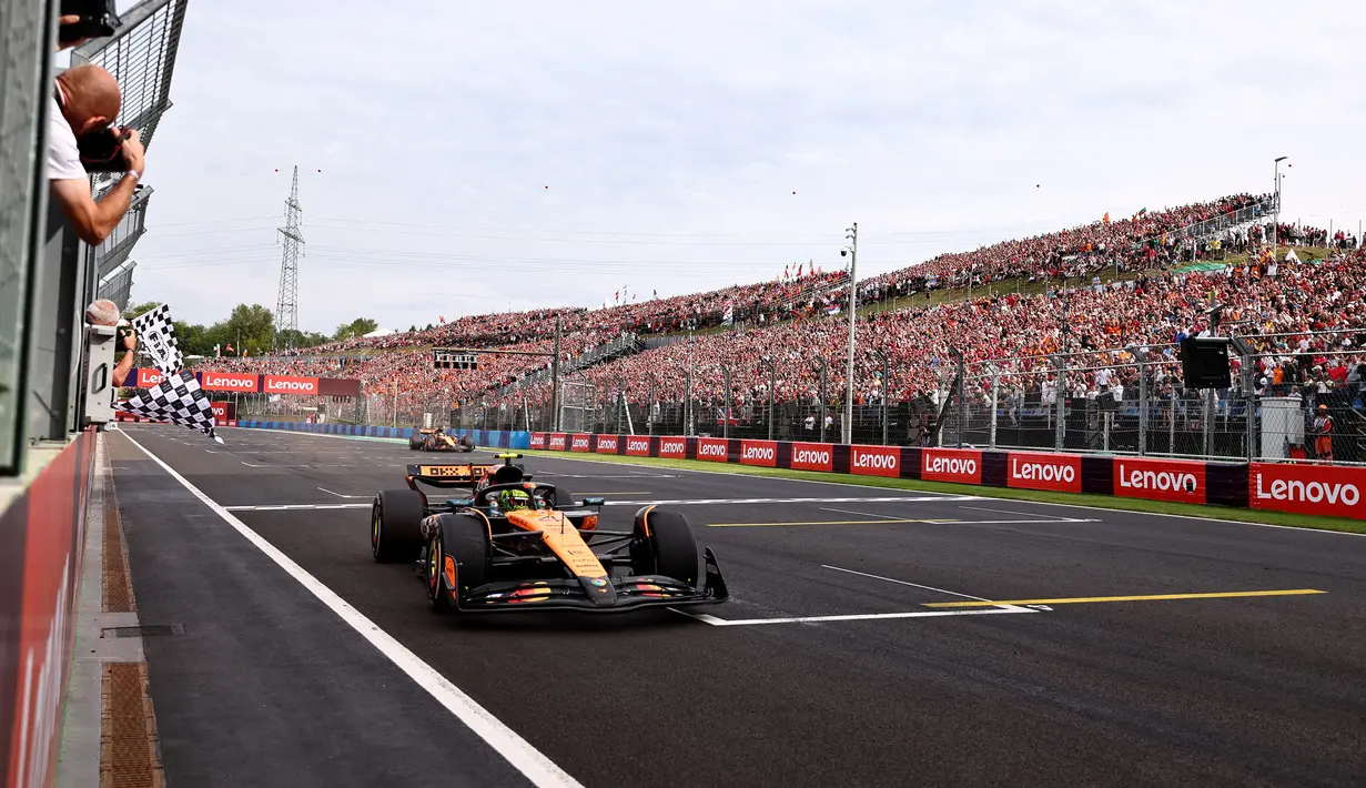 Pembalap McLaren, Lando Norris melintasi garis finis dalam ajang balap Formula 1 GP Hungaria 2025 di sirkuit Hongaroring, Minggu (03/08/2025) waktu setempat. (AFP/Pool/Anna Szilagyi)