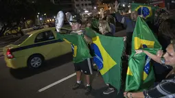 Warga turun ke jalan merayakan keputusan Hakim menjatuhkan hukuman ke mantan Presiden Brasil Luiz Inacio Lula da Silva di Rio de Janeiro, Brasil (12/7). Silva divonis terlibat korupsi dalam perusahaan minyak negara, Petrobras. (AFP Photo/Mauro Pimentel)