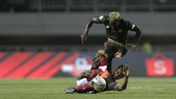Gelandang PS Tira Persikabo, Parfair Essengue, berebut bola dengan pemain Madura United pada laga Shopee Liga 1 di Stadion Pakansari, Bogor (12/7). Tira bermain imbang 2-2 atas Madura. (Bola.com/Yoppy Renato)