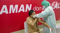 Vaksinator menyuntikkan vaksin COVID-19 kepada guru di SMA 70, Jakarta, Rabu (25/2/2021). Sebanyak 600 orang dari profesi guru, tenaga kependidikan, dan dosen akan divaksin COVID-19 hari ini. (Liputan6.com/Faizal Fanani)