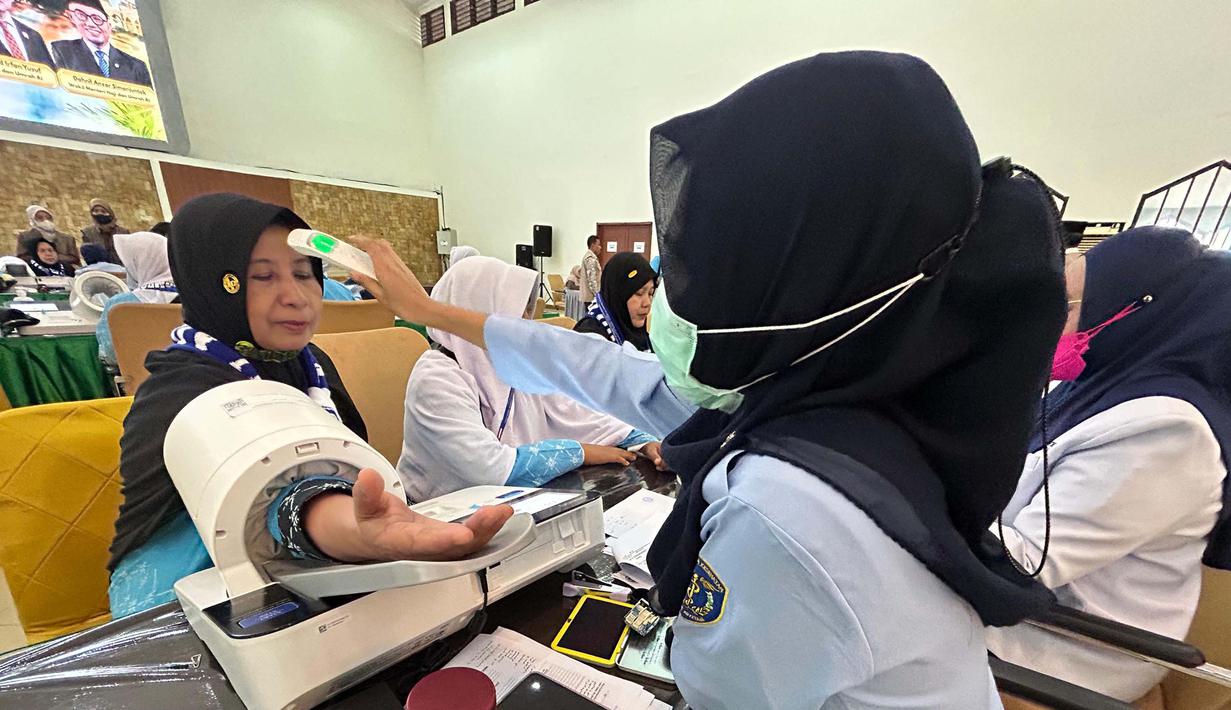 Kedatangan ini menandai dimulainya fase operasional pemberangkatan jemaah haji Indonesia tahun 1447 Hijriah/2026 Masehi. Tampak dalam foto, petugas memeriksa kesehatan calon haji setibanya di Asrama Haji Pondok Gede, Jakarta, Selasa (21/4/2026). (merdeka.com/Arie Basuki)