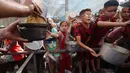 Beberapa anak antre untuk mendapatkan makanan dari dapur amal di kamp pengungsi Nuseirat, yang terletak di bagian tengah Jalur Gaza, pada 21 Oktober 2025. (Eyad BABA/AFP)