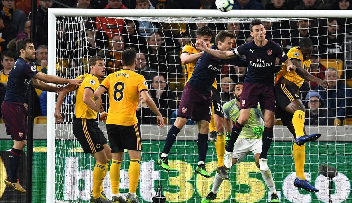 Aksi duel udara Nacho Monreal dan Koscielny pada laga lanjutan Premier League yang berlangsung di Stadion Molineux, Wolverhampton, Kamis (25/4). Arsenal kalah 1-3 kontra Wolves. (AFP/Paul Ellis)