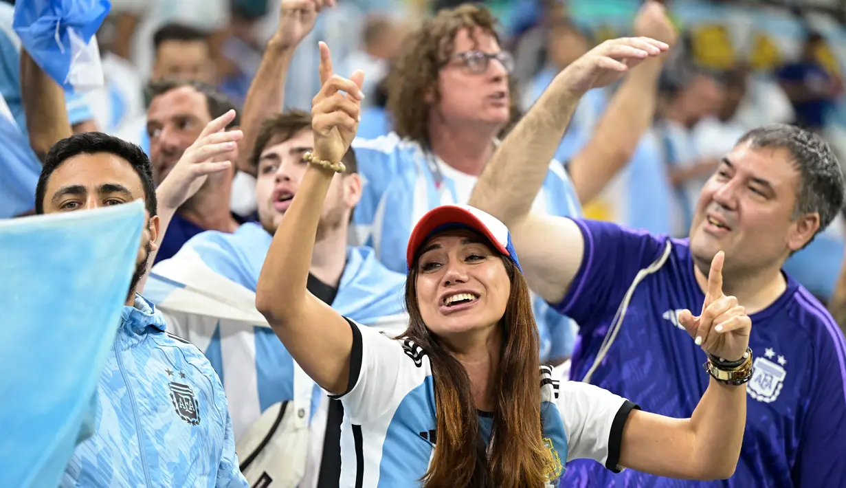 Seorang fans wanita Argentina bersorak di tribun sebelum pertandingan semifinal Piala Dunia Qatar 2022 antara Argentina dan Kroasia di Stadion Lusail di Lusail, utara Doha, Rabu (14/12/2022). (AFP/Juan Mabromata)