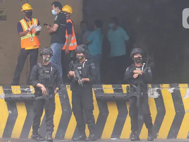 Polisi bersenjata lengkap berjaga saat penjemputan vaksin Covid-19 Sinovac di Terminal Kargo Bandara Soekarno-Hatta, Tangerang, Kamis (31/12). TNI dan Polri diterjunkan untuk mengawal kedatangan vaksin Covid-19 dari Bandara Soetta menuju PT Bio Farma di Bandung. (Liputan6.com/Angga Yuniar)
