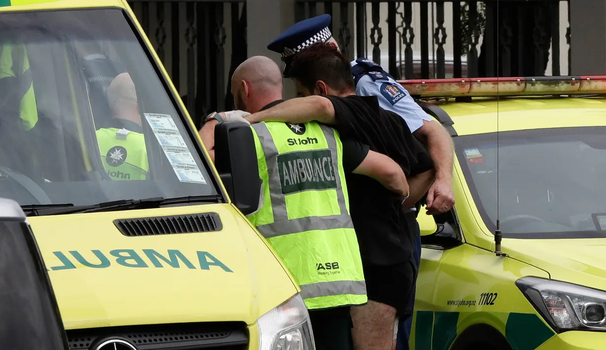 Polisi dan staf ambulans membantu seorang lelaki yang terluka dalam insiden penembakan di Masjid Al Noor, Christchurch, Selandia Baru, Jumat (15/3). Tiga korban penembakan adalah perempuan dewasa dan seorang lagi adalah gadis cilik. (AP Photo/Mark Baker)