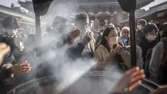 Orang-orang berdoa di sekitar pembakar dupa di kuil Sensoji menjelang liburan Tahun Baru di Tokyo pada 30 Desember 2022. Kuil Sensoji dikenal sebagai tempat wisata paling terkenal di Tokyo. (AFP/Yuichi Yamazaki)