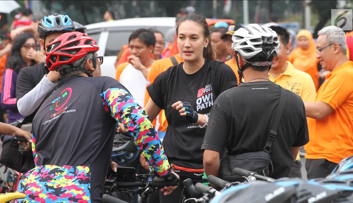 Artis peran Nadine Chandrawinata berbincang dengan rekannya saat mengikuti kampanye gerakan #BebasButaHuruf di kawasan Sudirman, Jakarta, Minggu (13/). Kampanye itu digelar dengan mengadakan kegiatan bersepeda (Liputan6.com/Herman Zakharia)