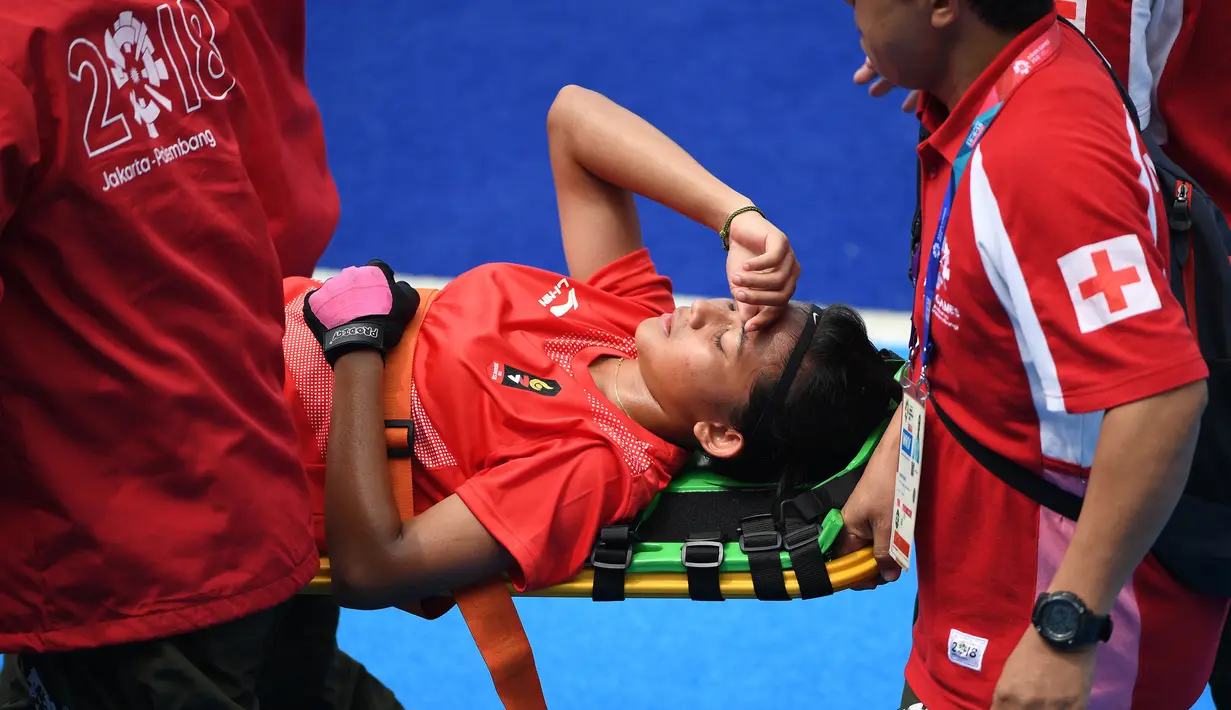 Atlet hoki Indonesia, Suwito Yuanita Rahmadhani ditandu oleh tim medis karena cedera saat melawan Chinese Taipei dalam Asian Games 2018 di Jakarta, Rabu (29/8). (ANTARA FOTO/ INASGOC/Dadang Tri/pras/18)