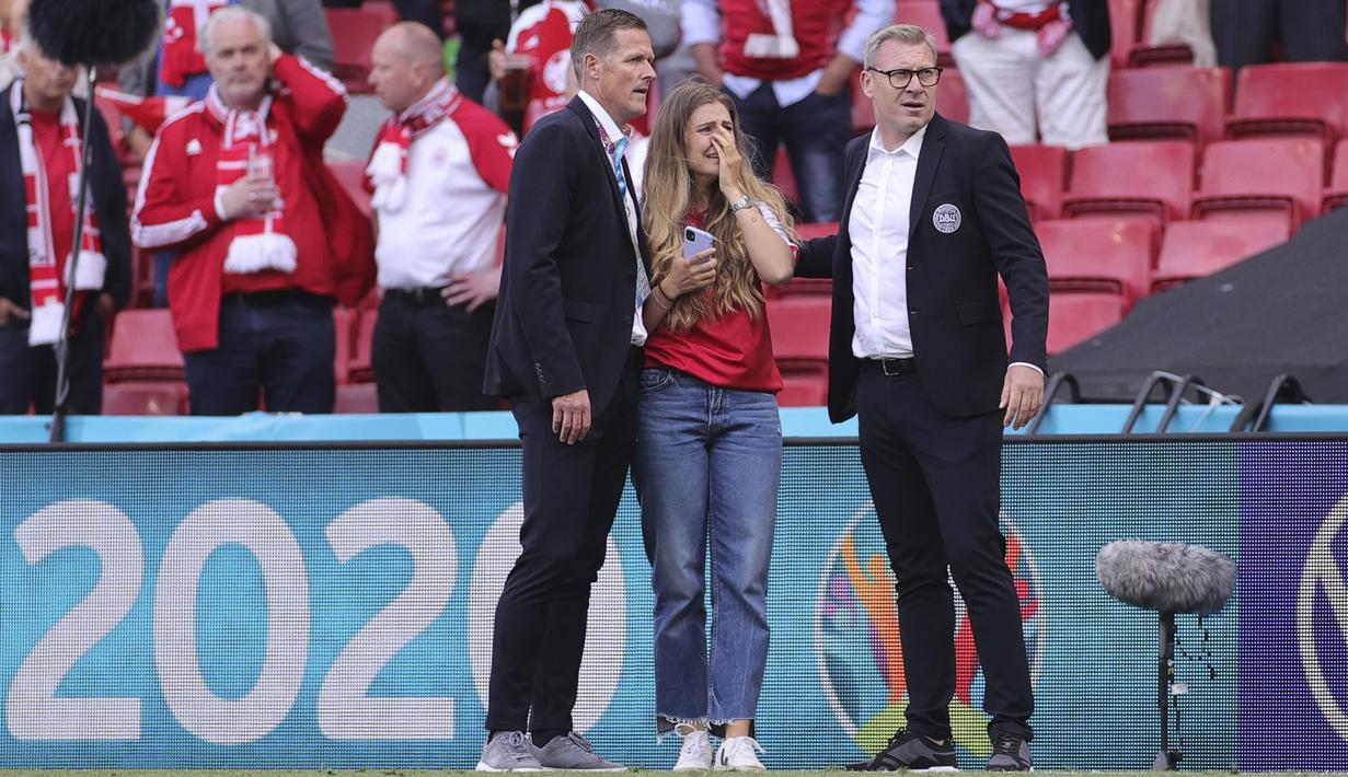 Ekspresi cemas dan sedih paling nampak ditunjukkan oleh istri Christian Eriksen, Sabrina Kvist Jensen. Ia hanya bisa menunggu kabar dari tim medis yang sedang menangani suaminya dari pinggir lapangan. (Foto: AP/Pool/Friedemann Vogel)