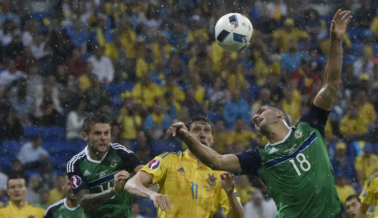 Pemain Irlandia Utara, Aaron Hughes (kanan) menghalau bola dari kejaran pemain Ukraina, Yevhen Seleznyov pada laga grup C  Euro 2016 di Stadion Parc Olympique Lyonnais, Kamis ( 16/6/2016) WIB. (AFP/Philippe Desmazes)
