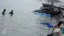 Petugas Basarnas dan Pol air mengamati proses pengangkatan bangkai kapal Zahro Express di Pelabuhan Muara Angke, Jakarta, Rabu (4/1). Pengangkatan kapal yang mulai tenggelam itu menggunakan drum kosong yang diisi helium. (Liputan6.com/Gempur M Surya)