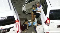 Pemudik makan bersama anak-anak sambil menanti waktu masuk kapal di Dermaga II Pelabuhan Penyebrangan Merak, Banten, Senin (3/6/2019). Sambil menanti waktu bongkar muat kapal penyebrangan, pemudik memanfaatkan waktu untuk makan bersama. (Liputan6.com/Helmi Fithriansyah)