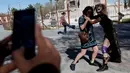 Pegulat Jerman 'Diosa del Rhin' (Dewi Rhin) berpose dengan seorang warga saat aksi kesetaraan gender di Ciudad Juarez, Meksiko (13/3/2016). Selain pegulat, Rhin juga merupakan seorang aktivis perempuan. (Reuters/Jose Luis Gonzalez)