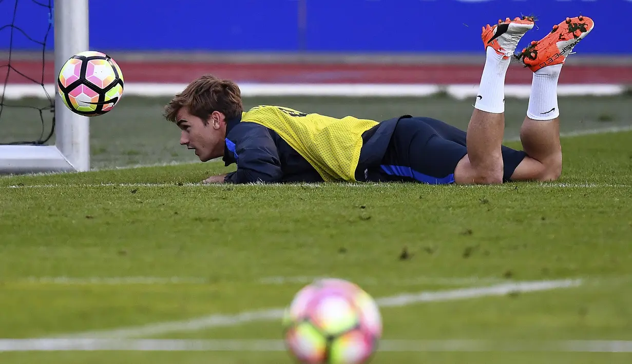 Antoine Griezmann menyundul bola sambil tiduran pada sesi latihan timnas Prancis di Clairefontaine-en-Yvelines dekat Paris, (4/10/2016). Prancis akan melawan Bulgaria pada kualifikasi Piala Dunia 2018. (AFP/Franck Fife)