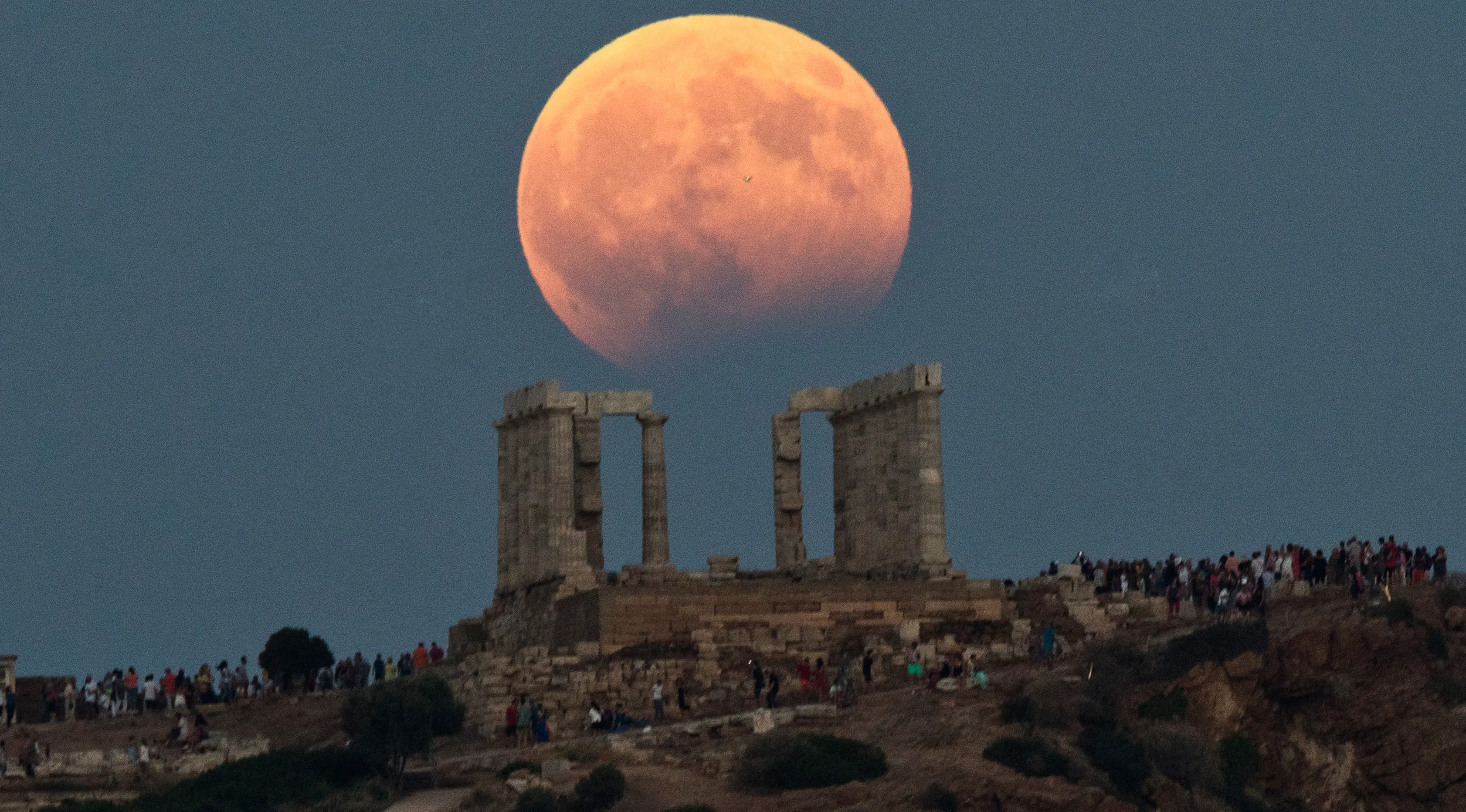 Gerhana bulan parsial terlihat di atas kuil Poseidon di Cape Sounion, Yunani, Senin (7/8). Gerhana bulan parsial terjadi ketika bumi bergerak di antara bulan dan matahari, tapi tidak persis dalam satu garis. (AP Photo/Petros Giannakouris)