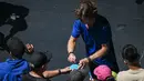 Petenis asal Rusia Andrey Rublev memberikantanda tangan setelah kemenangannya melawan Dominic Thiem dari Austria selama pertandingan tunggal putra mereka pada hari kedua Australia Terbuka di Melbourne, Selasa (17/1/2023). Berburu tanda tangan menjadi salah satu aktivitas fans yang menonton langsung Australian Open 2023. (ANTHONY WALLACE / AFP)