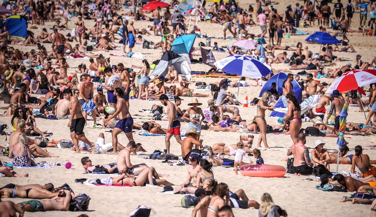 Orang-orang mengunjungi pantai Bondi di Sydney, Australia pada 5 Oktober 2020. Pengunjung ramai berjemur dan bermain di pantai dan berenang di laut saat pandemi Covid-19 masih berlangsung.  (Photo by DAVID GRAY / AFP)