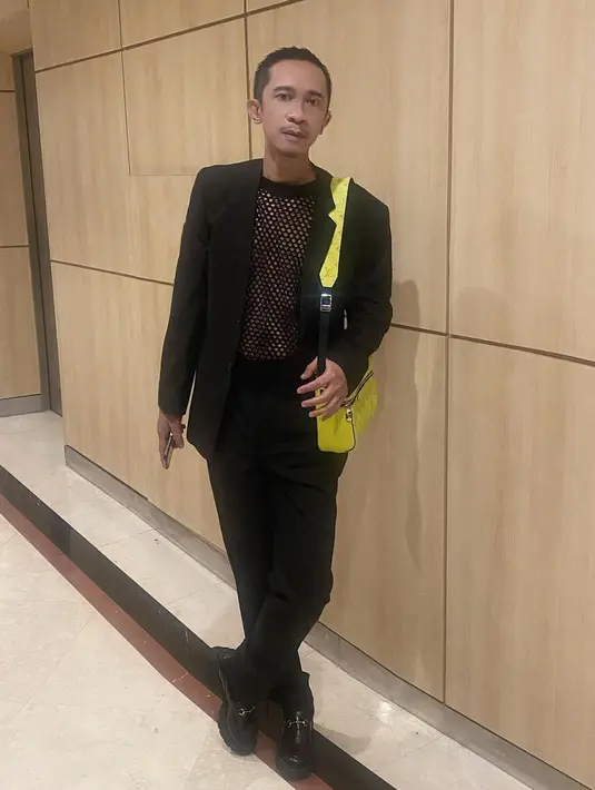 Aming dengan OOTD serba hitamnya. Ia mengenakan inner jaring, ditumpuk mengenakan blazer dan celana panjang, serta alas kaki yang semuanya berwarna hitam. Ia terlihat menambahkan sentuhan tas kuning sebagai pemanis dari keseluruhan penampilannya. [Foto: Instagram/amingisback]