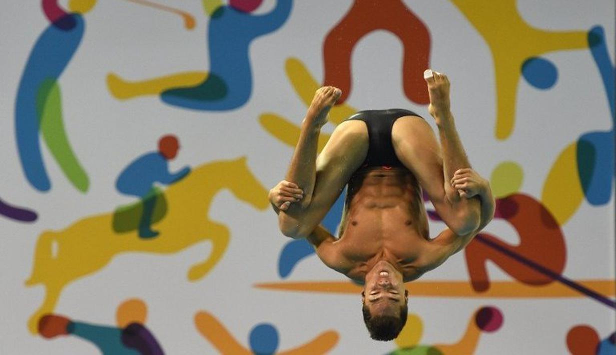 Peloncat indah Kolombia, Sebastian Morales, saat berlomba di nomor papan 3m Pan Am Games 2015  di Toronto, Kanada (10/7/2015). (AFP PHOTO/TIMOTHY A. CLARY)