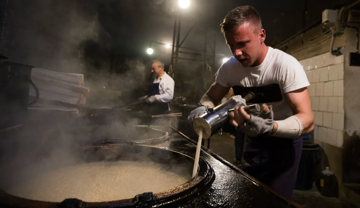 Karyawan memasukkan adonan donat khas Spanyol atau churros ke dalam minyak panas di restoran dessert tradisional La Manueta, Pamplona, Spanyol, Rabu (10/7/2019). Tekstur churros yang seperti donat membuatnya sangat cocok dicelup saus atau hanya diberi taburan gula halus. (JAIME REINA/AFP)