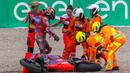 Sejumlah track marshal saat menolong pembalap Prima Pramac Racing, Jorge Martin ketika terjatuh saat MotoGP Jerman 2024 yang berlangsung di Sirkuit Sachsenring, Jerman, Minggu (07/07/2024) waktu setempat. (AFP/Radek Mica)