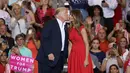 Presiden AS, Donald Trump saat ingin mencium istrinya, Melania Trump selama reli kampanye di Bandara Internasional Orlando Melbourne, Florida (18/2). Donald Trump terlihat mesra dengan sang istri saat pertemuan tersebut. (Joe Raedle / Getty Images / AFP)