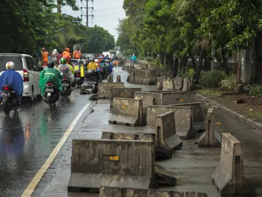 Kondisi separator busway yang berserakan pascabanjir di Jalan Daan Mogot, Cengkareng, Jakarta, Jumat (3/1/2020). Separator busway tersebut berantakan akibat banjir yang menerjang sejak kemarin. (Liputan6.com/Faizal Fanani)