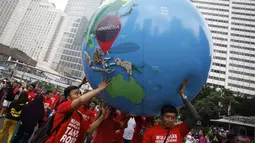 Sebuah miniatur bola dunia ikut dibawa saat aksi  mendukung ratifikasi Kerangka Kerja Pengendalian Tembakau (FCTC) di Bundaran HI, Jakarta, Minggu (15/2/2015). (Antara Foto/ Sigid Kurniawan)