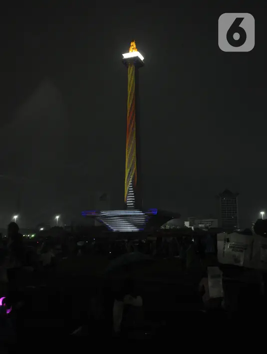 Penampilan video mapping saat malam pergantian tahun di kawasan Monumen Nasional, Jakarta, Selasa (31/12/2019). Meski Jakarta diguyur hujan sejak Selasa (31/12) sore, warga tetap mendatangi kawasan Monas untuk merayakan malam pergantian tahun. (Liputan6.com/Helmi Fithriansyah)