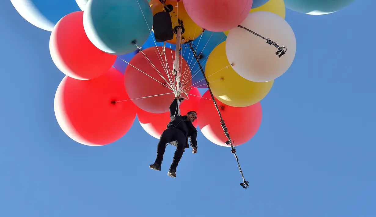 David Blaine terbang dengan memegang balon helium saat melakukan aksi "Ascension" di Page, Arizona, Amerika Serikat, Rabu (2/9/2020). David Blaine berhasil melakukan aksi ekstrem tersebut dengan terbang setinggi 7.600 meter. (David Becker/GETTY IMAGES NORTH AMERICA/Getty Images via AFP)