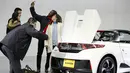 Pengunjung berselfie disamping mobil Honda S660 di markas besar Honda Motor Co di Tokyo, Jepang, (24/2). Mobil Honda S660 adalah mobil sport yang memiliki dua tempat duduk berkatagori mobil yang sangat kecil. (REUTERS/Thomas Peter)