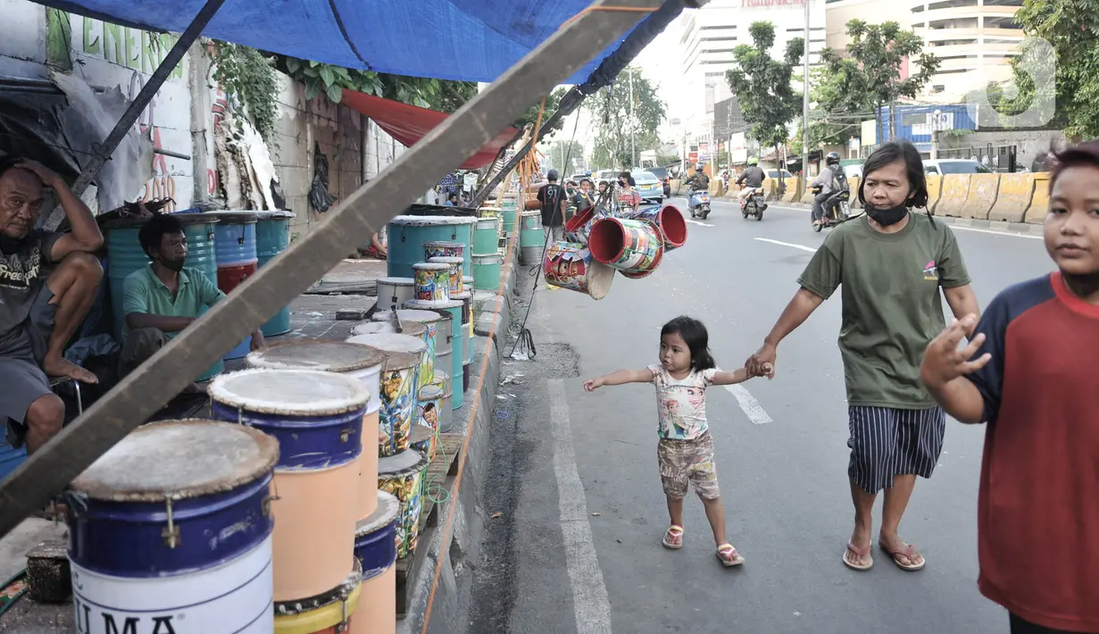 Pejalan kaki melintas di depan penjual beduk di kawasan Tanah Abang, Jakarta, Selasa (19/5/2020). Pedagang mengaku memasuki seminggu jelang Lebaran penjualan beduk hanya mencapai puluhan, berbeda jauh dengan tahun lalu yang mampu menjual hingga ratusan beduk. (merdeka.com/Iqbal Nugroho)