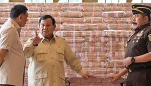 Presiden Prabowo Subianto (tengah) berbicara dengan Jaksa Agung Sanitiar Burhanuddin (kanan) dan Menteri Pertahanan Indonesia Sjafrie Sjamsoeddin di samping tumpukan uang kertas rupiah Indonesia senilai 800 juta USD di gedung Kejaksaan Agung Republik Indonesia, Jakarta, Senin 20 Oktober 2025. (BAY ISMOYO/AFP)