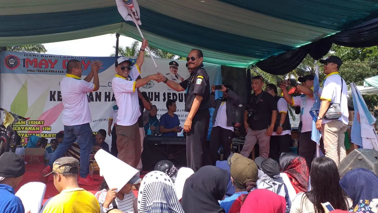 Nampak panitia senam May Day tengah memberikan sebuah hadiah bagi buruh yang beruntung mendapatakannya, pada perayaan May Day hari ini