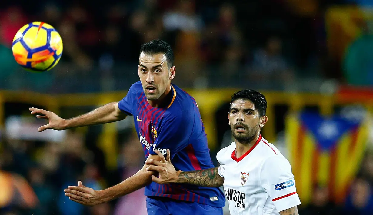 Gelandang Barcelona, Sergio Busquets berusaha mengejar bola dari kawalan pemain Sevilla, Ever Banega saat bertanding pada lanjutan La Liga Spanyol di Camp Nou, Barcelona, Spanyol, (4/11). Barcelona menang 2-1 atas Sevilla. (AP Photo/Manu Fernandez)