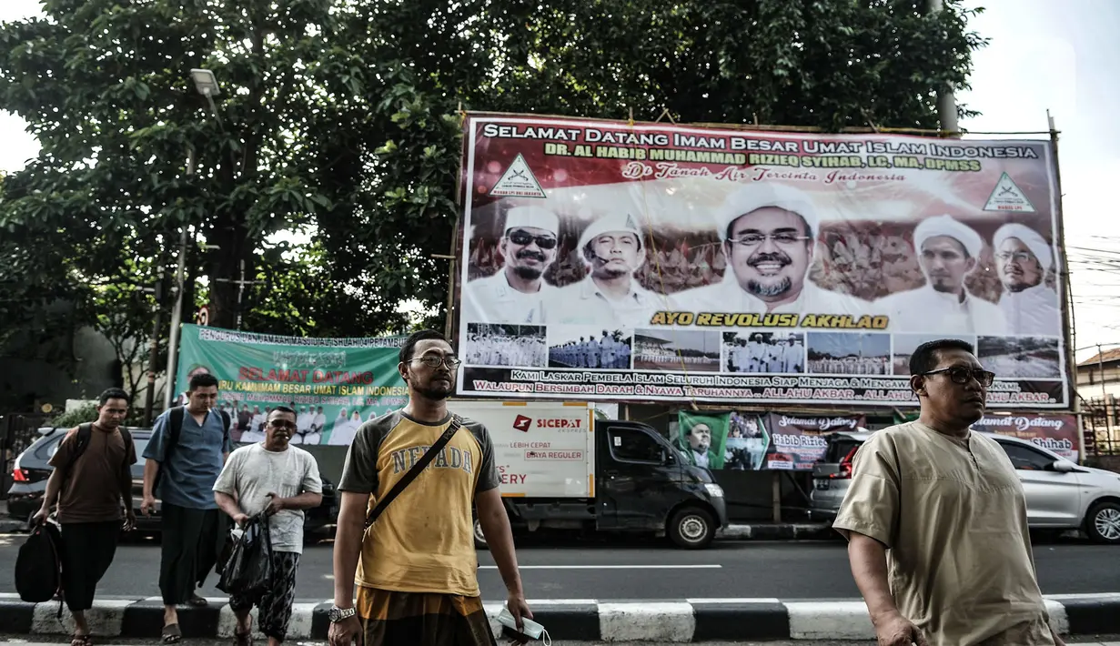 Anggota FPI dari luar daerah melintasi baliho penyambutan Habib Rizieq Shihab saat tiba di Jalan Petamburan III, Tanah Abang, Jakarta, Senin (9/11/2020). Sejumlah pedagang yang menjual beragam atribut FPI pun terlihat berjejer di sepanjang jalan. (merdeka.com/Iqbal S. Nugroho)