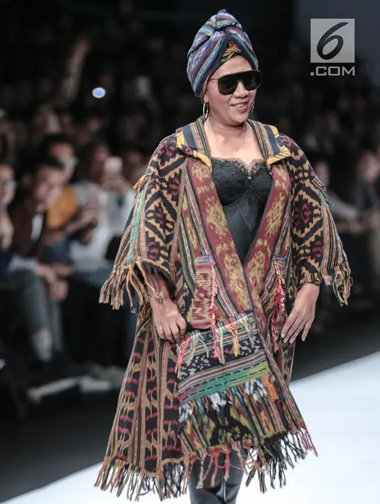 Menteri KKP, Susi Pudjiastuti memperagakan busana rancangan Anne Avantie pada Jakarta Fashion Week 2019 di Senayan City, Selasa (23/10). Melengkapi penampilan nyentriknya, Menteri Susi menggunakan kain tenun sebagai turban. (Liputan6.com/Faizal Fanani)
